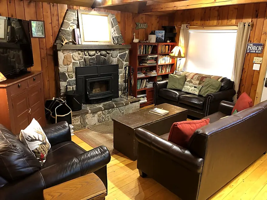 The knotty-pine living room with the stone fireplace